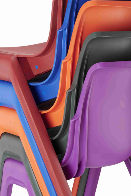 Stack of colorful Ergostak chairs highlighting ergonomic design and durability for classrooms.